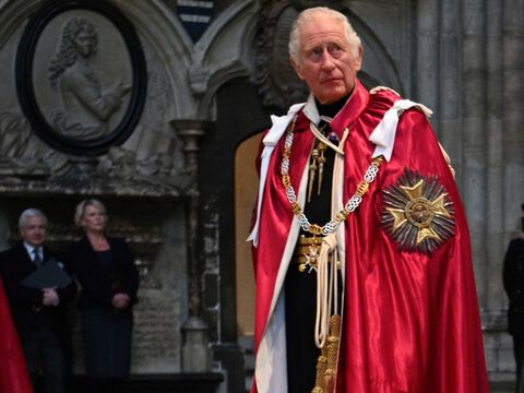 Prinz Charles in rotem Mantel schaut ernst 
