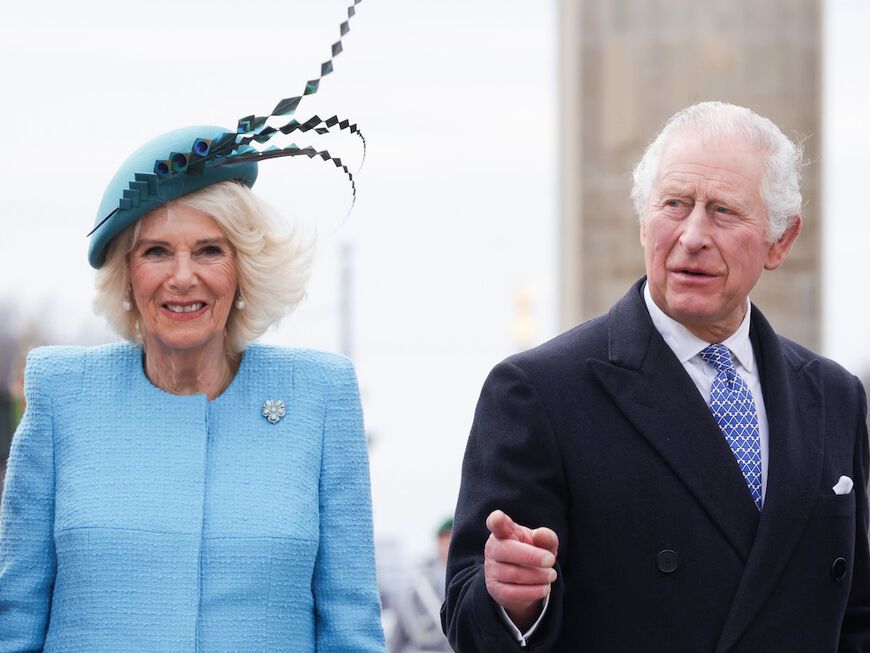 König Charles und Königin Camilla lächeln in Kamera