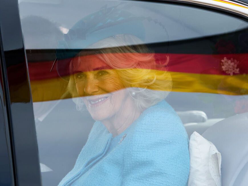 Königin Charles lächelt aus dem Auto