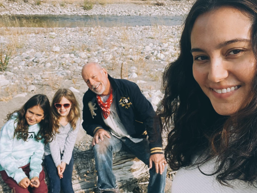 Emma Heming Willis macht ein Selfie mit Bruce Willis und ihren Töchtern, die auf einem Baumstamm sitzen