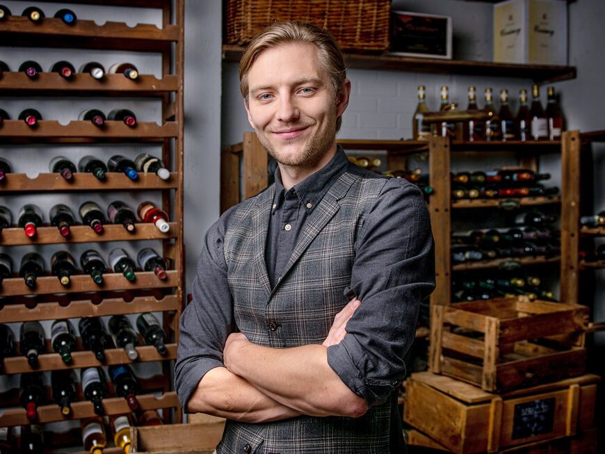 Schauspieler Matthias Zera posiert in einem Weinkeller