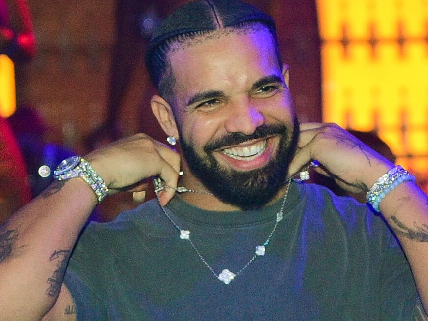 Drake lacht und richtet seine Kette