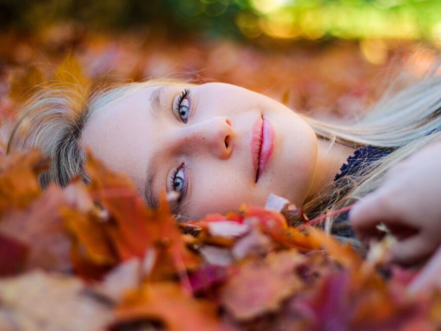 Frau mit perfektem Teint im Herbstlaub