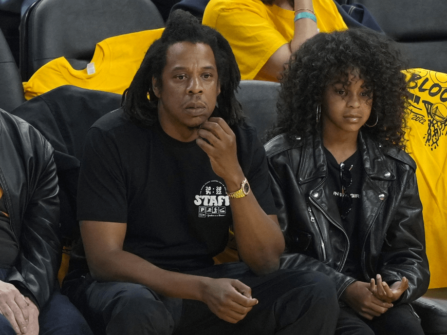 Jay-Z und Blue Ivy Carter sitzen nebeneinander und gucken ernst