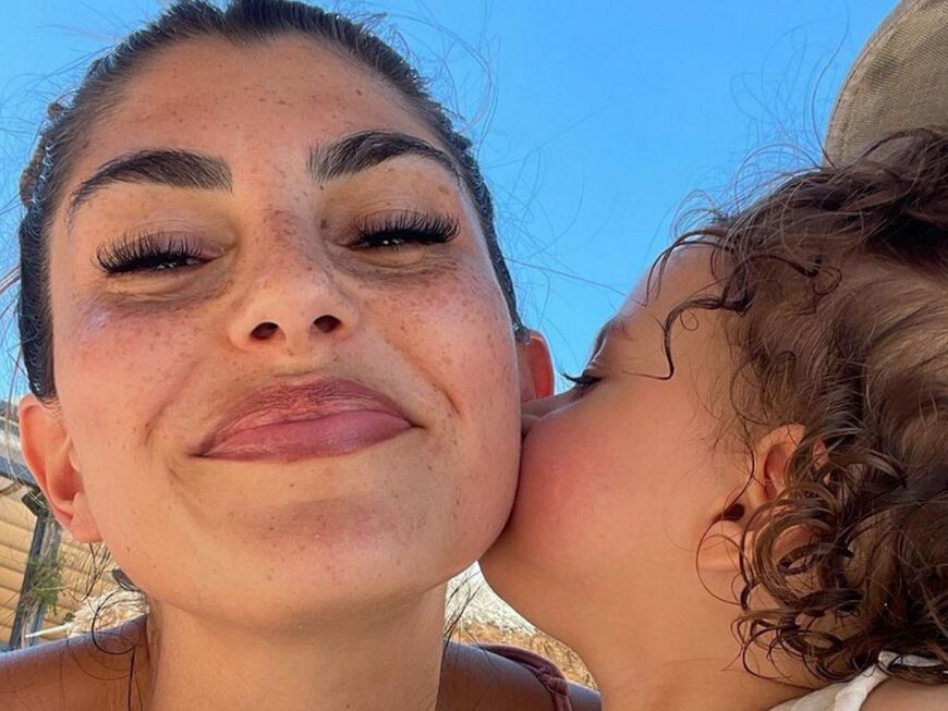 Yeliz Koc bekommt einen Wangenkuss von Tochter Snow am Strand bei einem Instagram-Selfie