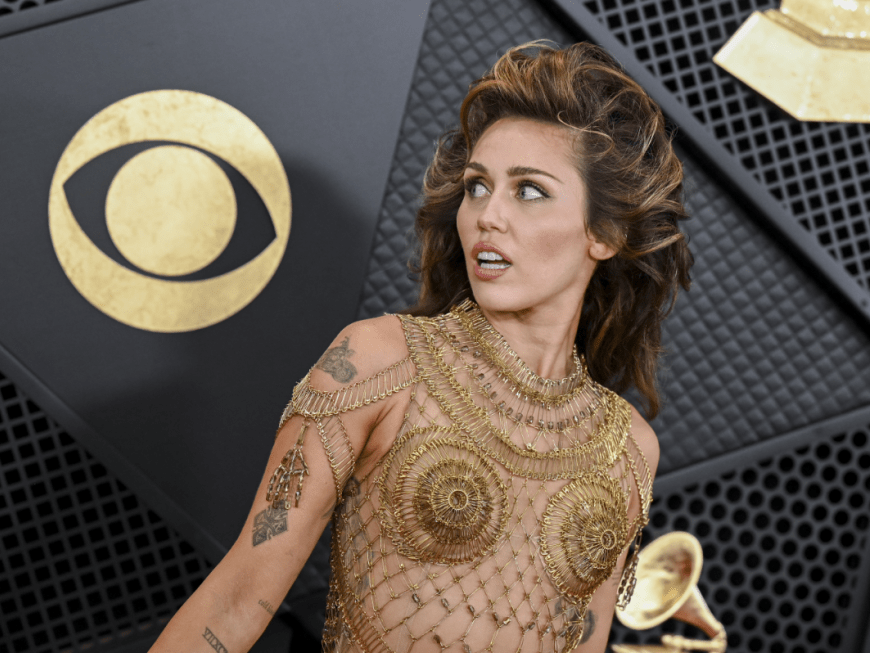 Miley Cyrus in einem goldenen Kleid guckt zur Seite bei den Grammys 2024