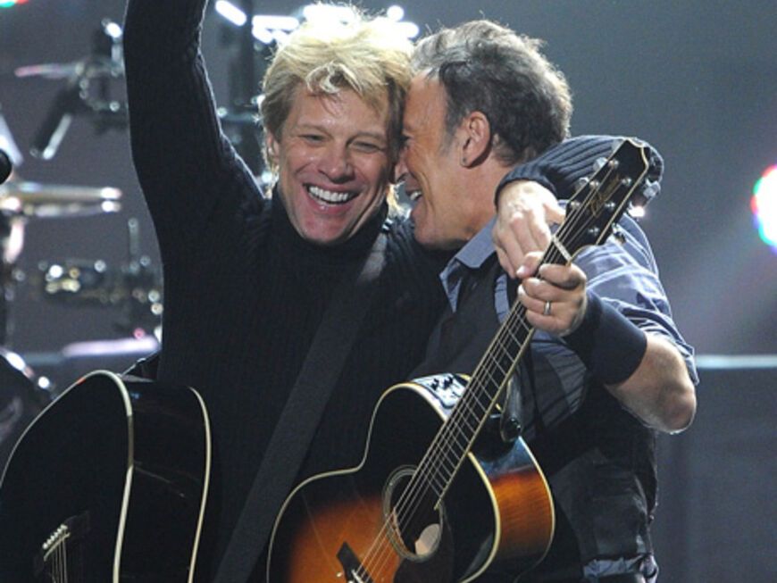 Jon Bon Jovi und Bruce Springsteen liegen sich in den Armen. Das nach dem Veranstaltungsdatum "12-12-12" benannte Konzert wurde weltweit von etwa 65 Fernsehsendern übertragen