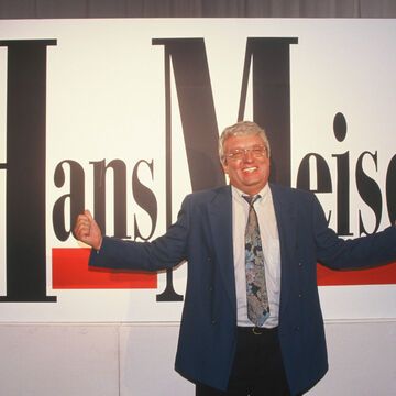 Hans Meiser vor einem Plakat zur Talkshow "Hans Meiser"