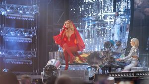 Beyoncé sitzt auf einem Klavier und singt