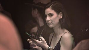 Lena Meyer-Landrut hält ein Handy in der Hand, ihr Gesicht sieht ernst aus