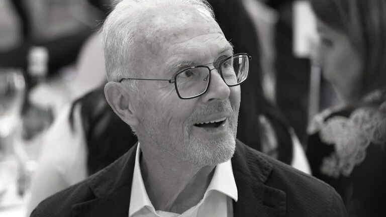 Franz Beckenbauer schaut lächelnd mit Brille zur Seite
