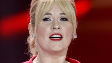 Maite Kelly guckt traurig zur Seite im roten Kleid 