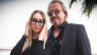 Shania Geiss fasst sich an ihre Sonnenbrille, Robert Geiss mit Sonnenbrille auf steht neben ihr