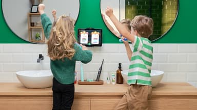 zwei kinder putzen zähne mit playbrush und jubeln