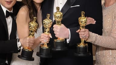 Vier Personen halten Oscar-Preise in den Händen