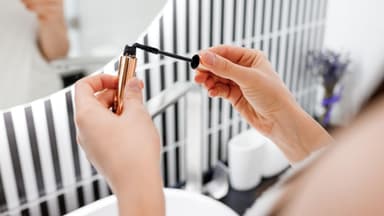 Mascara vor schwarz-weißer Wand