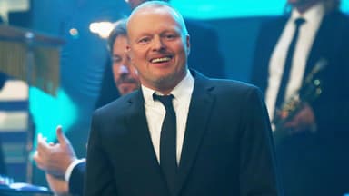 Stefan Raab lächelt im Anzug