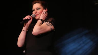 Andrea Neuenhofen, bekannt als AnNa R., von Rosenstolz steht mit Mikrofon auf der Bühne