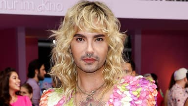 Bill Kaulitz mit blonden locken vor pinker wand