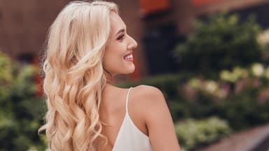 Blondine von seitlich hinten mit Locken