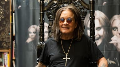 Ozzy Osbourne sitzt lächelnd auf einem Thron