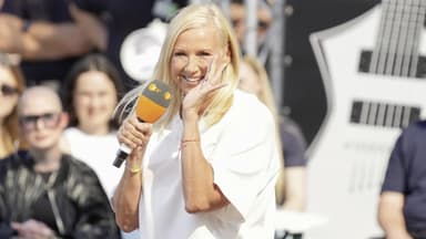 Andrea Kiewel lacht mit Hand am Mund