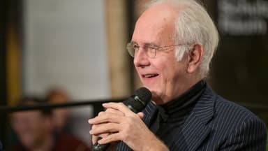 Harald Schmidt von der Seite mit einem Mikrofon in der Hand
