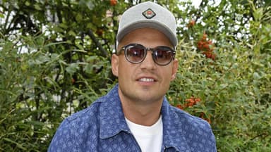 Pietro Lombardi lächelt mit Sonnenbrille vor grünen Büschen