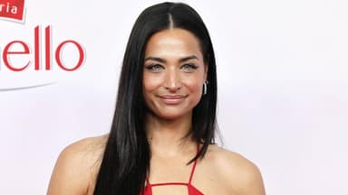 Amira Aly lächelt im roten Kleid