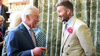 König Charles und David Beckham stehen sich gegenüber und lachen