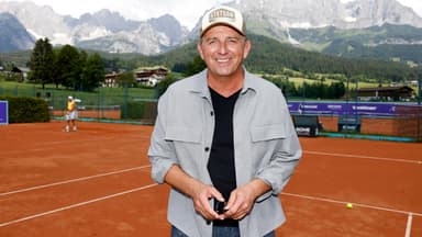 Hans Sigl vor Bergkulisse auf Tennisplatz