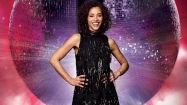 Nadja Benaissa im schwarzen Kleid vor Discokugel