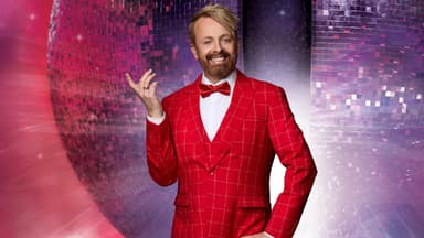 Ross Antony im roten Anzug vor Discokugel