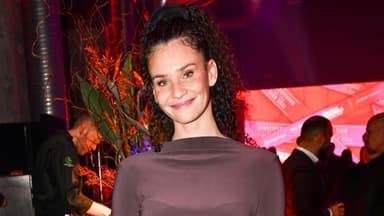 Betty Taube lächelt vor Blumen-Bouquet