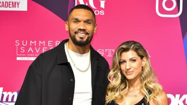 Dominic und Sarah Harrison vor einer pinken Wand