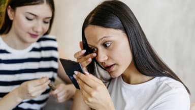 Frau entfernt Mascara-Reste unter dem Auge