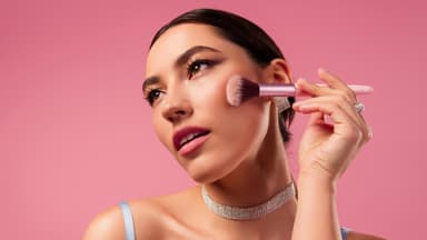 Frau trägt Blush mit Pinsel auf