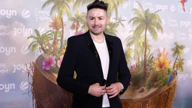 Menderes Bagci lächelt bei der Premiere von "Promis unter Palmen"