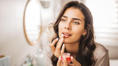 Frau trägt Lippenpflege auf