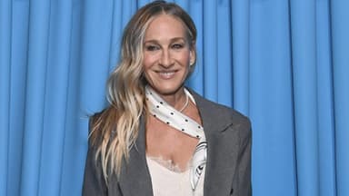 Sarah Jessica Parker strahlt vor blauen Vorhang
