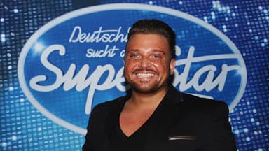 Menowin Fröhlich vor dem DSDS-Logo
