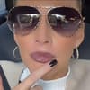 Peggy Jerofke mit Sonnenbrille, fasst sich an den Mund