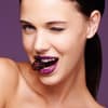Frau mit Brombeere im Mund