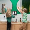 zwei kinder putzen zähne mit playbrush und jubeln