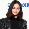 Selena Gomez vor weißer Wand mit Schrift