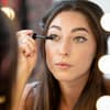 Frau tuscht Wimpern an