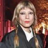 Mieze Katz mit geflochtenen Zöpfen und ernstem Blick