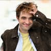 Robert Pattinson lächelt mit zerzausten Haaren