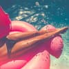 Eine Frau liegt auf einer Luftmatratze im Pool