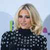 Pixie Lott trägt hochgeschlossenes Kleid und sieht glücklich aus
